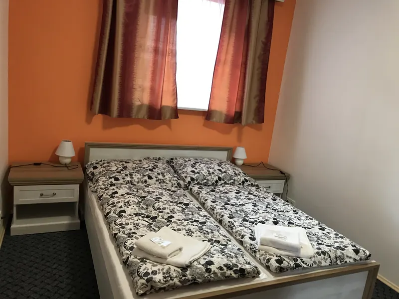 Ložnice s manželskou postelí a oranžovou stěnou