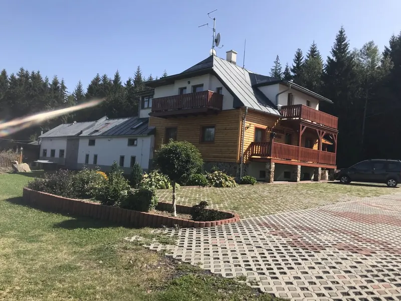 Penzion s květinovým záhonem a příjezdovou cestou